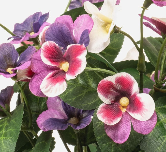 Künstliche Stiefmütterchen mit lila und weißen Blüten sowie grünen Blättern.