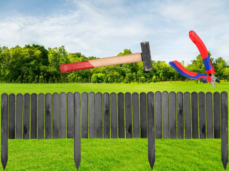 Szene mit einem Hammer, einer Gartenschere und einem Zaun auf einer Wiese vor Bäumen und blauem Himmel.