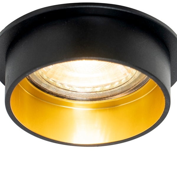 Runder Einbaustrahler in Schwarz mit goldenem Innenring und eingeschaltetem Leuchtmittel.