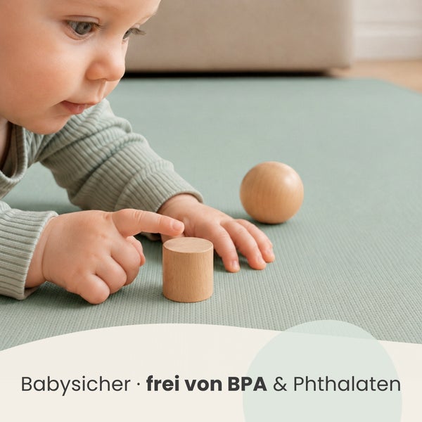 Kleinkind spielt auf einer rutschfesten Babymatte mit Holzspielzeug, frei von Bisphenol A und Phthalaten für hohe Sicherheit.