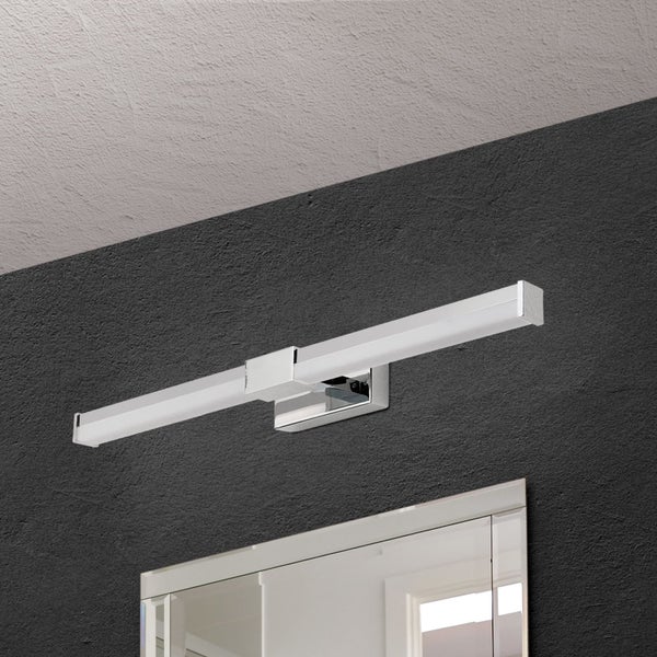 Moderne LED Spiegelleuchte für das Badezimmer mit verchromter Halterung montiert über einem Spiegel an einer dunklen Wand