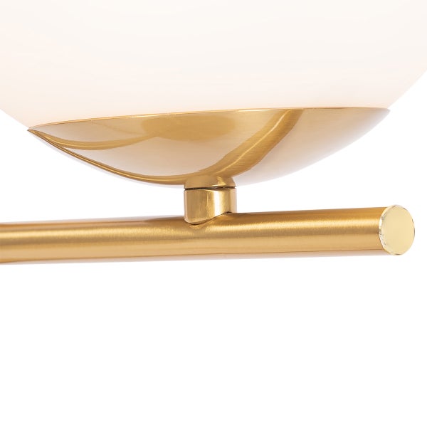 Detailaufnahme einer goldenen Deckenleuchte mit einem Schirm aus Glas.