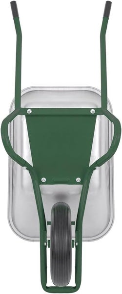 Im Bild ist ein Ilex-Kugelbaum vor einem Zaun mit Kletterpflanzen zu sehen.