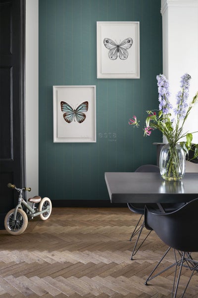 Dekoratives Zimmer mit einer Esstischgarnitur, einem Kinderfahrrad und einer gemusterten Tapete mit Schmetterlingsbildern