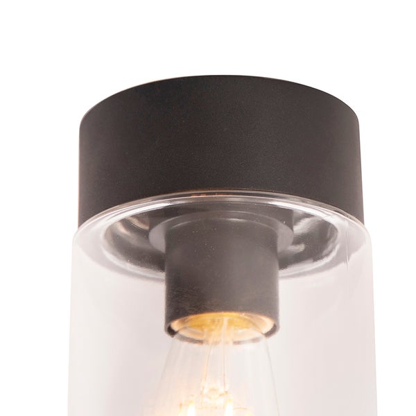 Moderne Wandleuchte mit mattschwarzer Halterung und zylindrischem Schirm aus klarem Glas.