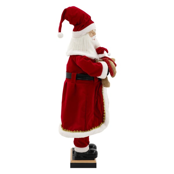 Weihnachtsmann-Figur mit Stofftier auf Sockel