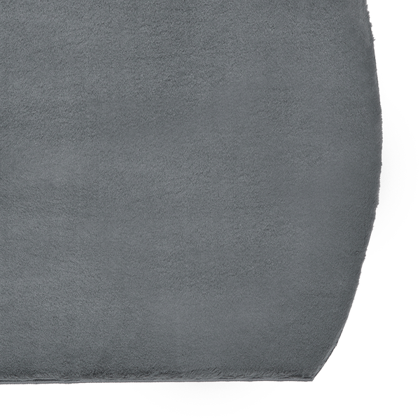 Nahaufnahme eines weichen, grauen Teppichs mit abgerundeter Ecke und samtiger Textur.