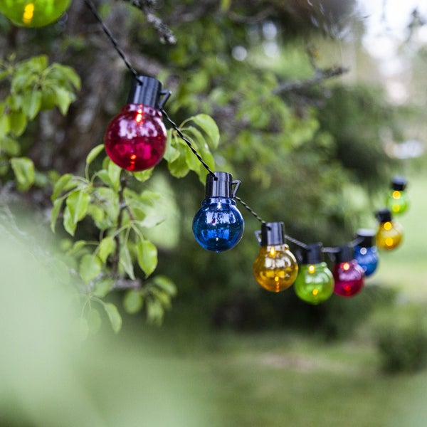 Lichterkette mit bunten Glühbirnen im Garten