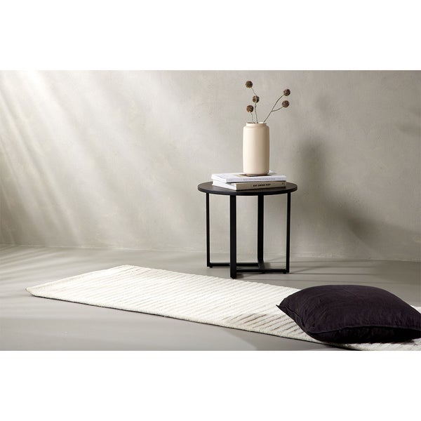 Raumansicht mit Teppich, Beistelltisch, Kissen und Dekoration für ein gemütliches Ambiente