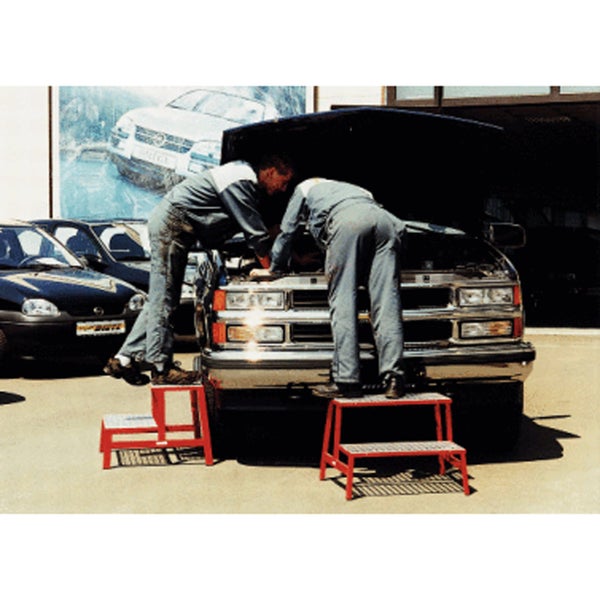 Mann auf einer zweistufigen Trittleiter neben einem Auto