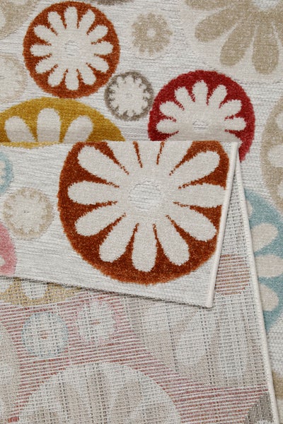 Teppich mit buntem Blumenmuster in flachgewebter Optik mit umgeschlagener Ecke und sichtbarer Rückseite.