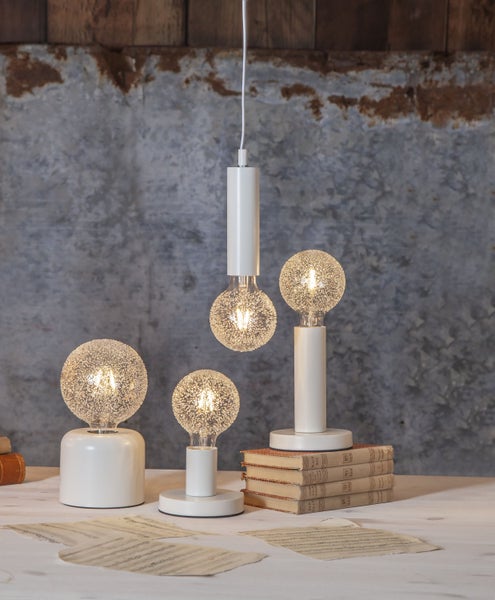 Dekorative Lampen mit Glühbirnen auf einem Tisch mit Notenblättern und Büchern.