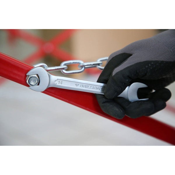 Ein Maulschlüssel der Größe 14 wird zum Anziehen einer Schraube verwendet. Eine Person trägt Schutzhandschuhe.