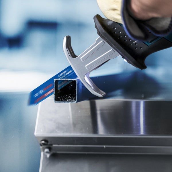 Eine Säbelsäge schneidet ein Metallrohr.