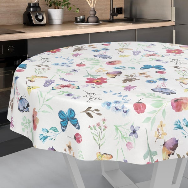 Runde Tischdecke mit floralem Aquarellmuster und Schmetterlingen auf einem Küchentisch.