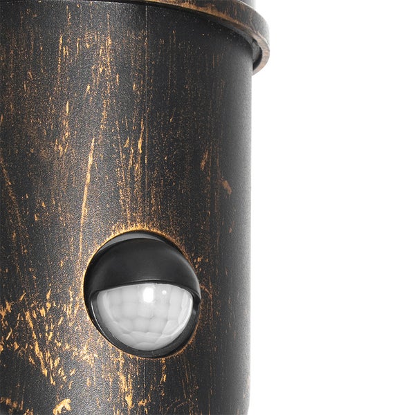 Nahaufnahme einer Außenleuchte mit integriertem Bewegungsmelder und antikem Finish.