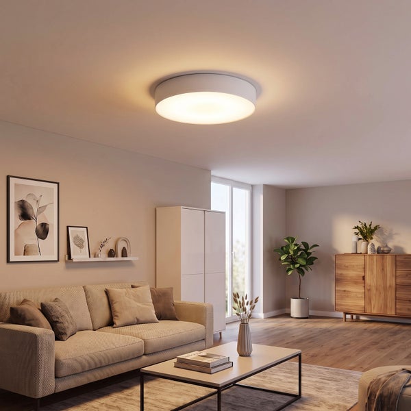 Runde LED Deckenleuchte in modernem Wohnzimmer mit warmem Licht für eine gemütliche Atmosphäre.