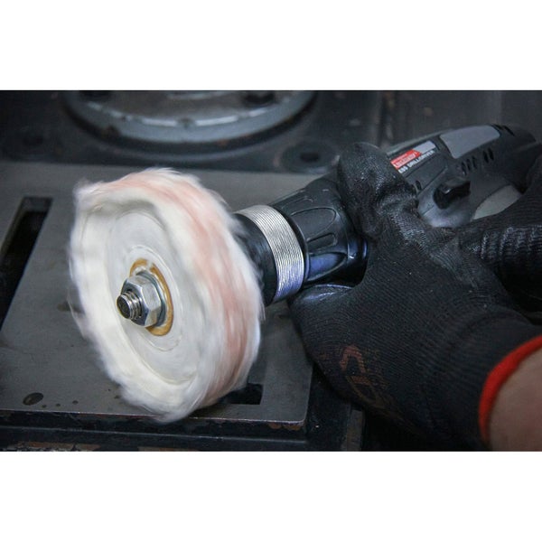 Eine Person benutzt eine Bohrmaschine mit einer Polierscheibe.