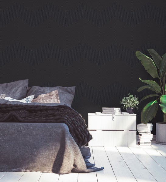 Schlafzimmer mit Bett, Nachttisch, Zimmerpflanzen und geometrischer Tapete