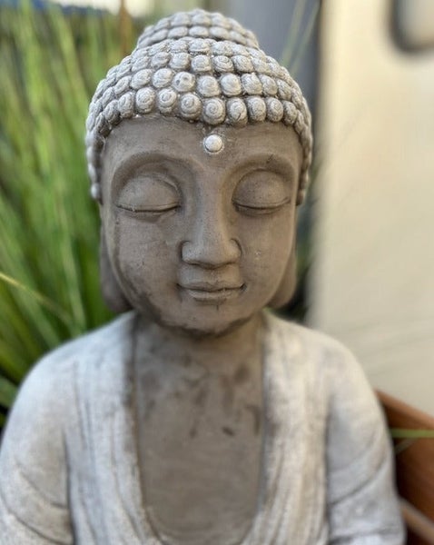 Buddha-Statue aus Stein für die Gartendekoration, Detailaufnahme des Kopfes mit geschlossenen Augen.