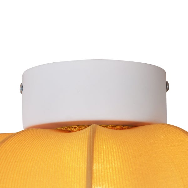 Nahaufnahme eines weißen zylindrischen Deckenbaldachins einer Leuchte mit orangefarbenem Stoffschirm.