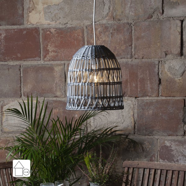 Hängelampe aus Rattan über einem Holztisch