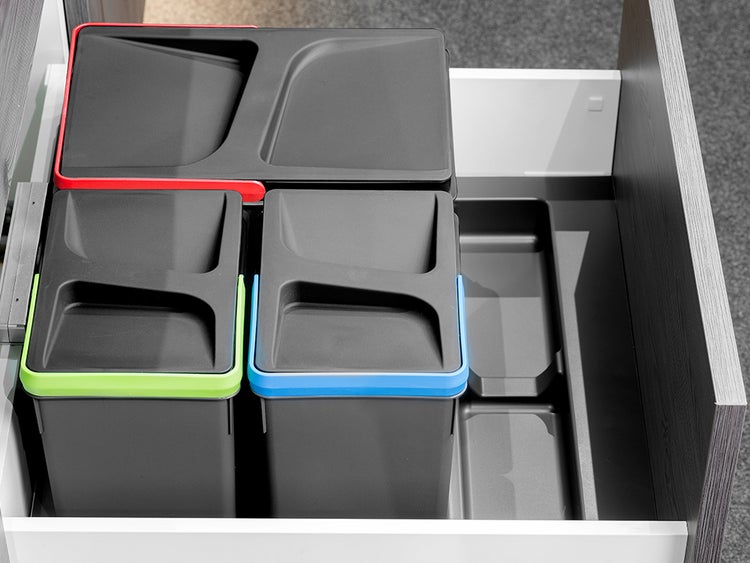 Mülltrennsystem aus Kunststoff in einer Küchenschublade mit drei Abfallbehältern mit Deckeln und einem Aufbewahrungsfach.