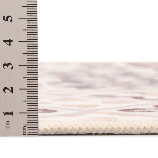 Seitenansicht einer Teppichkante mit einem Lineal zur Messung der Florhöhe von circa 1 Zentimeter.