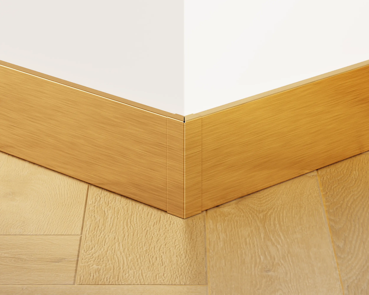 Detailaufnahme einer Holzfußleiste an einer Innenwandecke