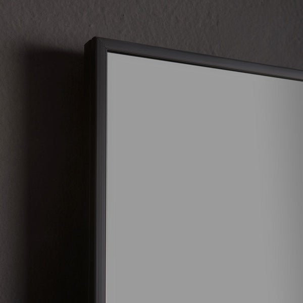 Nahaufnahme der Ecke eines Spiegels mit schwarzem Aluminiumrahmen.