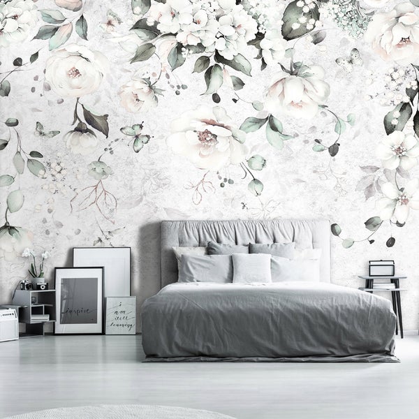 Schlafzimmer mit floraler Fototapete, Bett und dekorativen Elementen für ein gemütliches Ambiente.