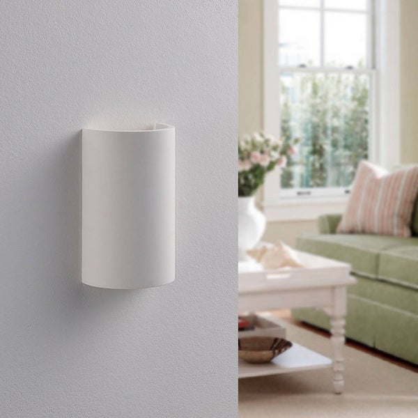 Weiße halbrunde Wandleuchte aus Gips an einer strukturierten Wand in einem hellen Wohnzimmer.