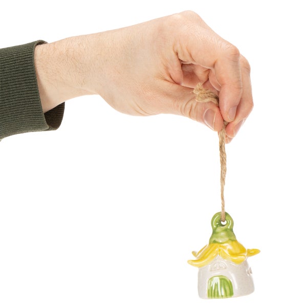 Hand hält Windspiel in Hausform