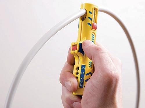 Handhabung eines gelben Abisolierwerkzeugs an einem Kabel