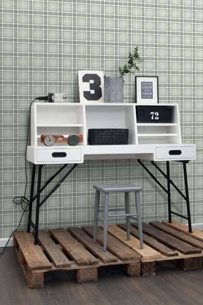 Weißer Schreibtisch mit Ablagefächern und schwarzem Metallgestell, kombiniert mit einem grauen Hocker und einer Palette als Untergrund.