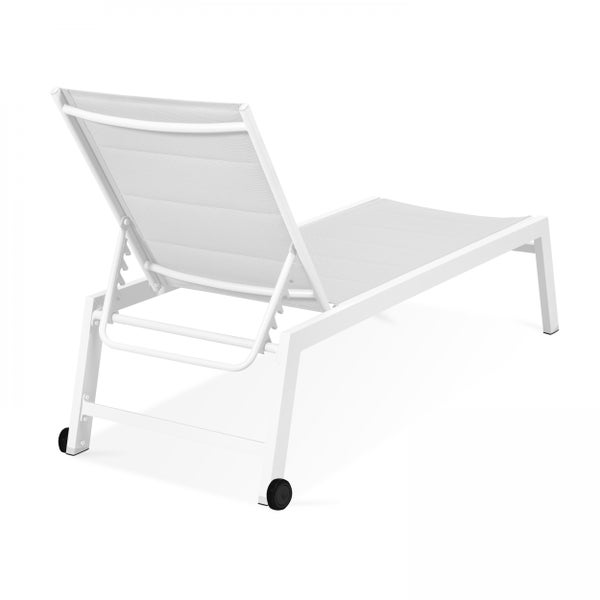 Zwei moderne Gartenliegen aus Aluminium mit hellen Textilbespannungen auf einer Rasenfläche neben einem Pool in einer grünen Gartenumgebung.