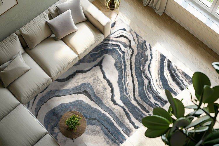 Wohnzimmer mit modernem Sofa und einem Teppich mit abstraktem, wellenförmigem Marmormuster in einem hellen, einladend gestalteten Wohnbereich.
