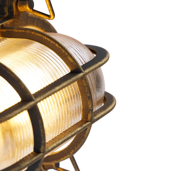 Detailaufnahme einer beleuchteten Industrie-Wandleuchte mit geriffeltem Glas und Schutzgitter aus Metall in Messing-Optik.