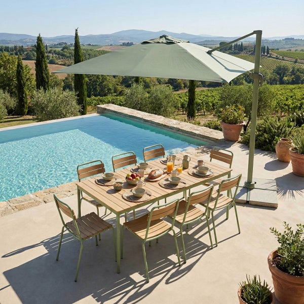 Moderne Gartensitzgruppe mit Holztisch und acht Stühlen unter einem grünen Ampelschirm auf einer hellen Terrasse am Pool.
