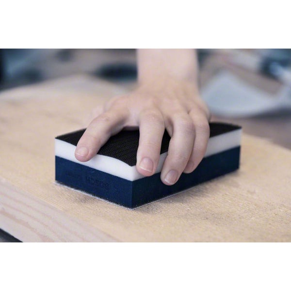 Handschleifklotz mit Schleifvlies auf Holzoberfläche