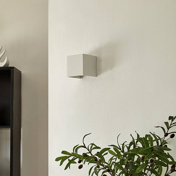 Moderne quadratische Wandleuchte in Würfelform an einer Wand montiert.