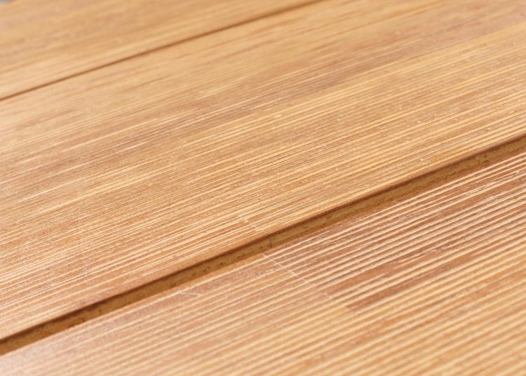 Nahaufnahme einer geriffelten Terrassendiele aus Holz mit sichtbarer Maserung.