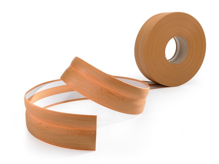 Eine Rolle selbstklebendes Dichtungsband in Holzoptik mit profilierter Oberfläche für den Abschluss von Arbeitsplatten oder Sockelleisten.