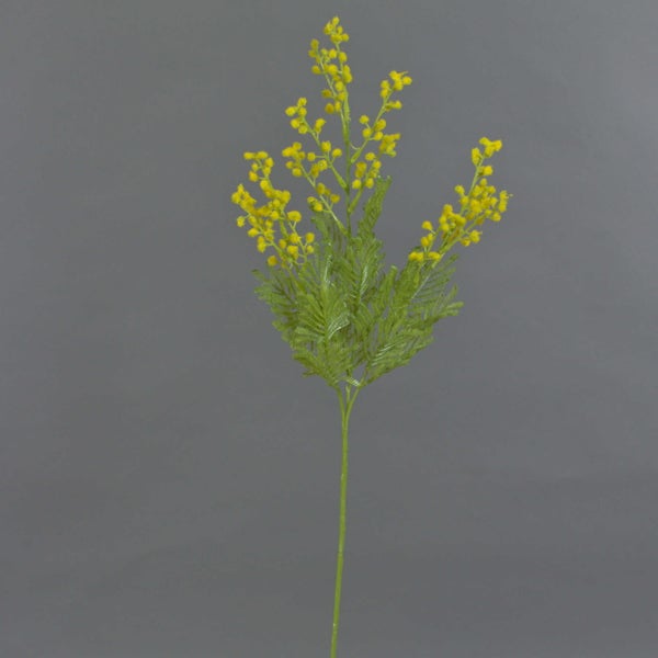 Künstlicher Mimosenzweig mit gelben Blüten und grünen Blättern.