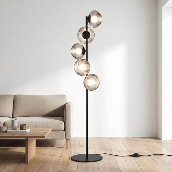 Moderne schwarze Stehleuchte mit fünf geriffelten Glasschirmen in einem hellen Wohnzimmer mit beigem Sofa und Holzboden.