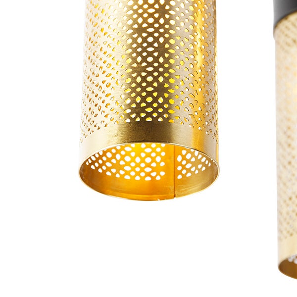 Detailaufnahme einer goldenen Hängelampe mit durchbrochenem Lampenschirm.