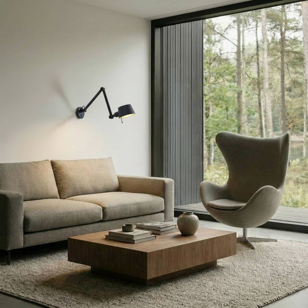 Wohnzimmer mit Sofa, Sessel, Couchtisch und verstellbarer Wandleuchte