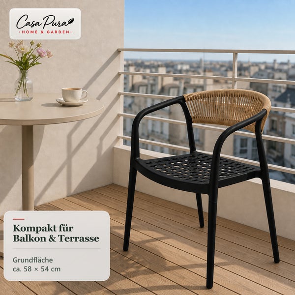 Gartenstuhl mit Armlehnen und Geflechtoptik auf einem Balkon mit kleinem Tisch vor einer Stadtkulisse.