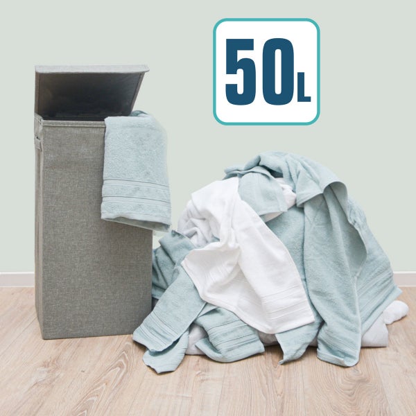 Grauer Wäschesammler aus Stoff mit 50 Liter Fassungsvermögen und geöffnetem Deckel neben einem Wäschehaufen.