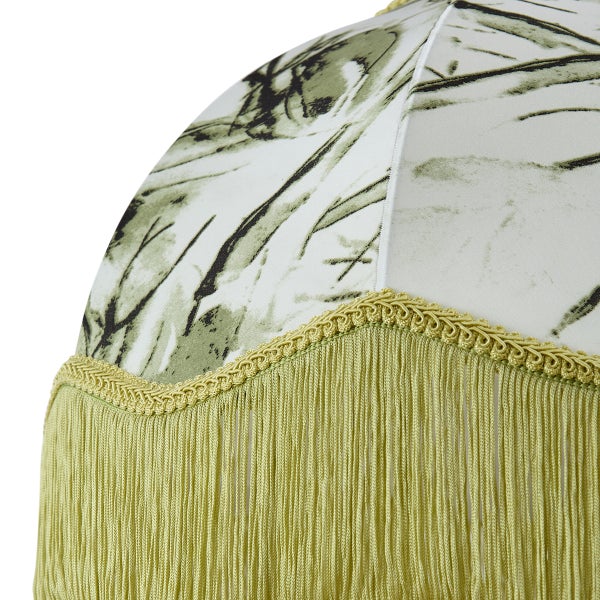 Detailansicht eines Lampenschirms mit botanischem Muster und dekorativen Fransen.